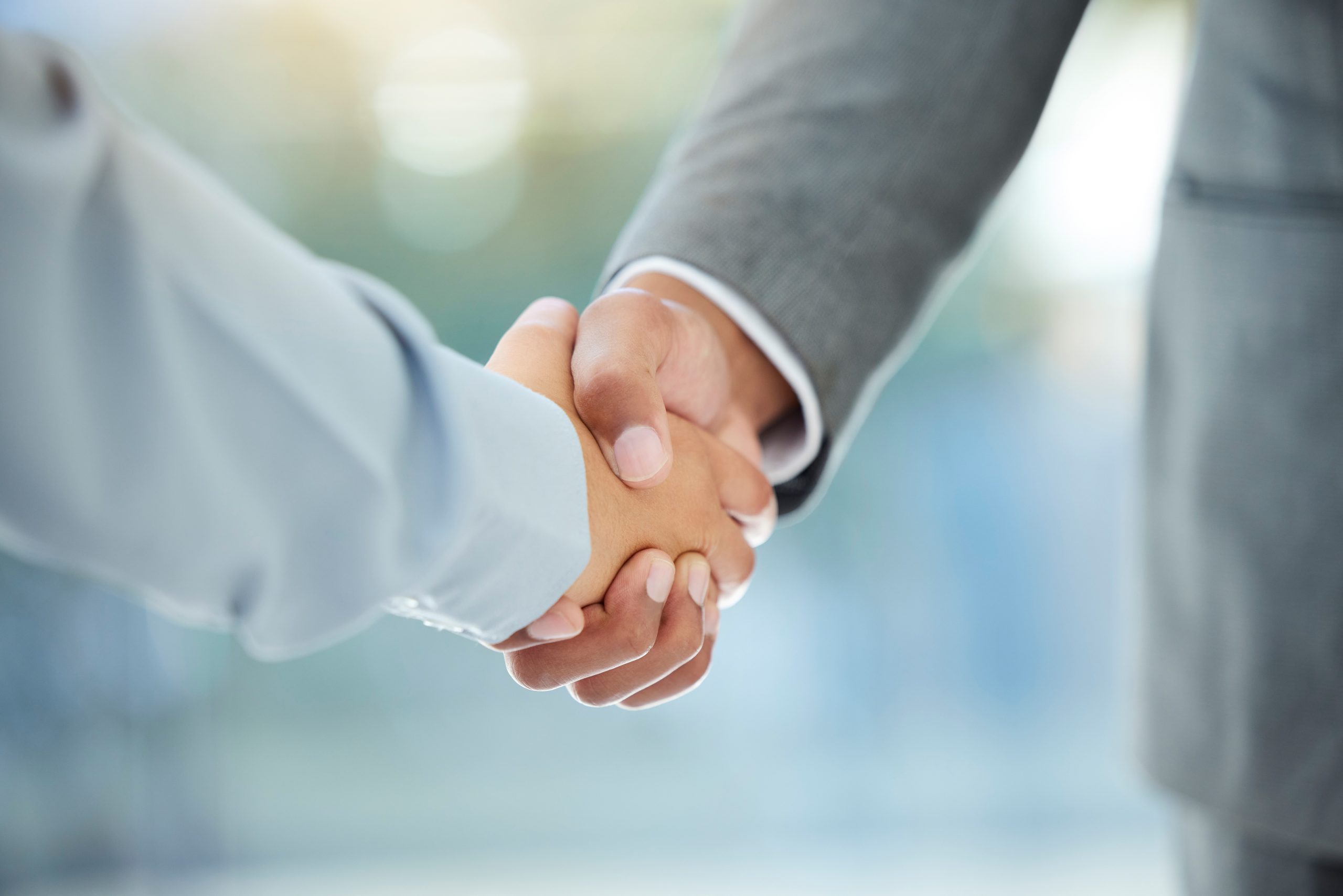 Cropped shot of two unrecognizable businesspeople shaking hands in an office.