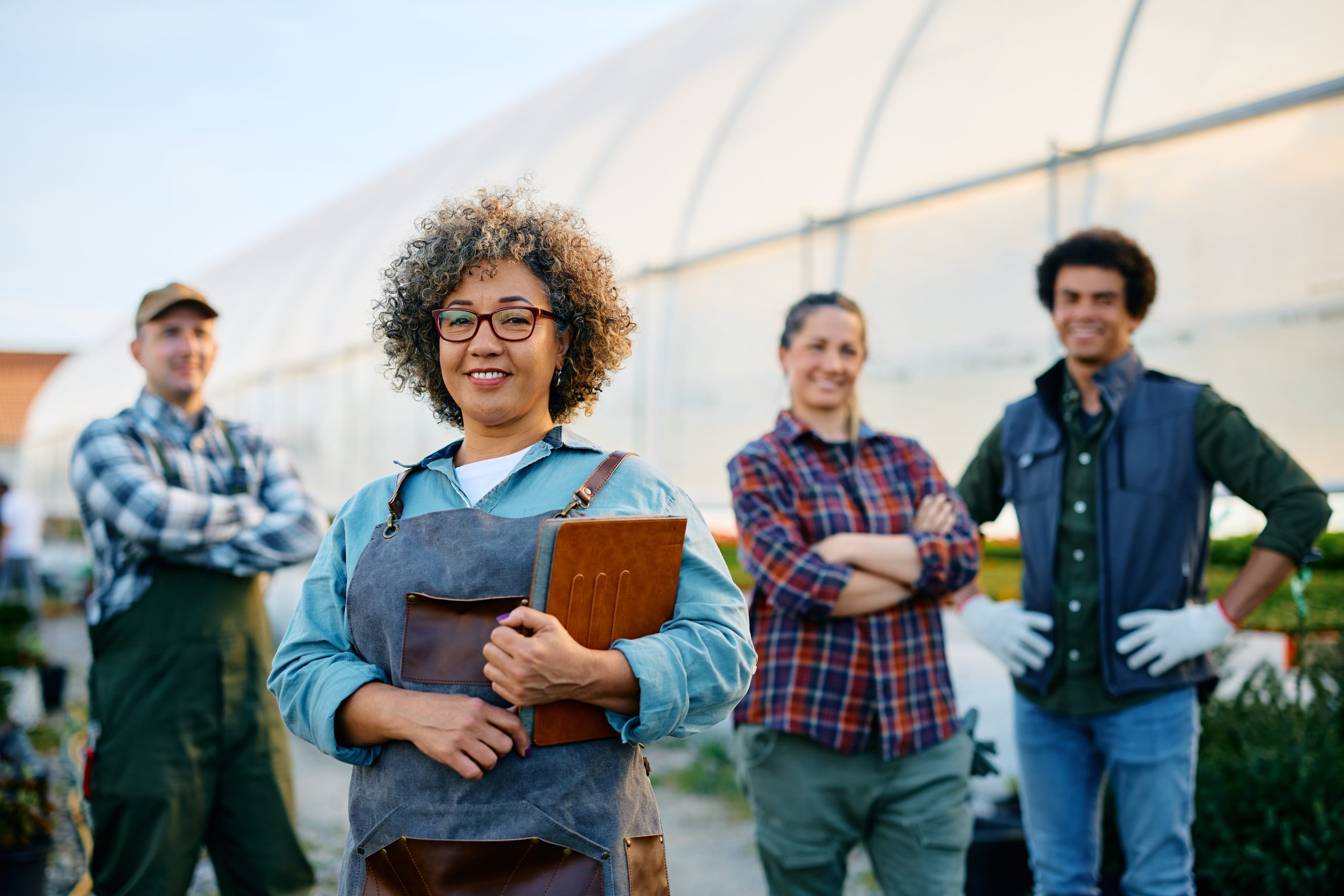 happy-greenhouse-owner-and-group-of-her-workers-lo-2023-11-27-05-16-34-utc (1)