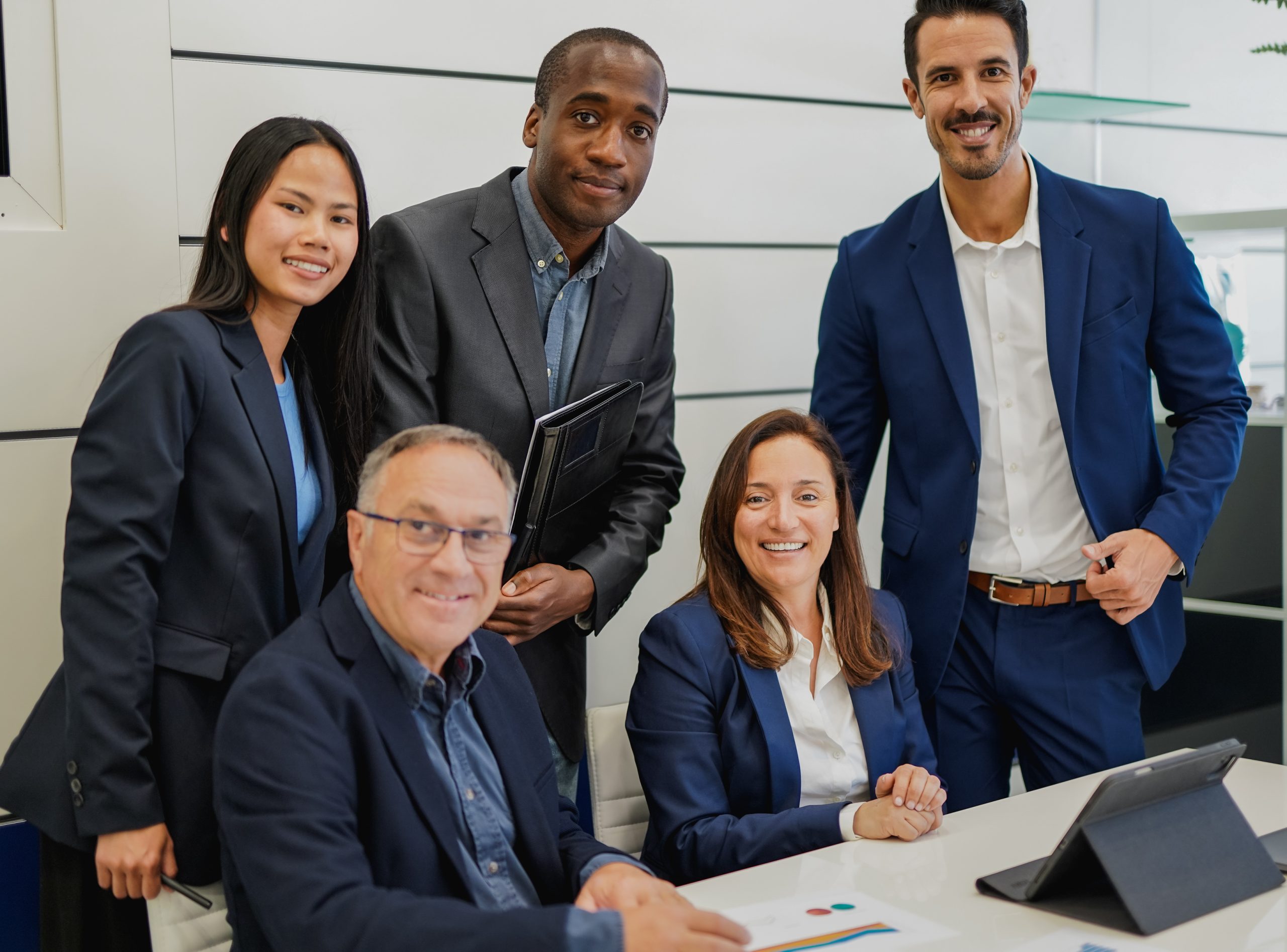 Multiracial business people smiling on camera inside modern offi